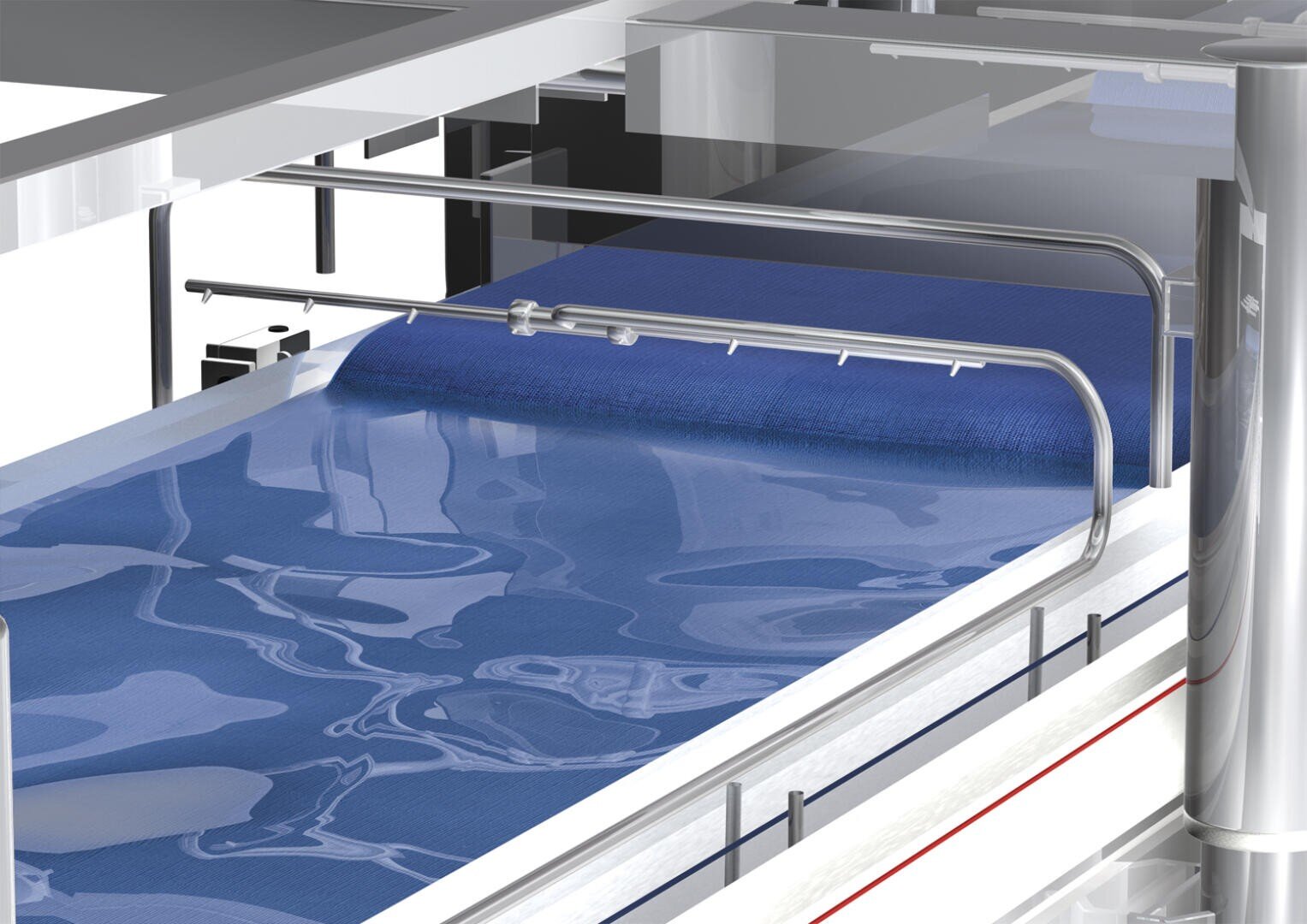 Eine Nahaufnahme einer Industriemaschine, durch deren Wasserbad sich ein blauer Stoff bewegt, während darüber Metallrohre verlaufen. Die Anordnung lässt auf einen Textilverarbeitungs- oder Waschvorgang in einer Fabrik schließen.