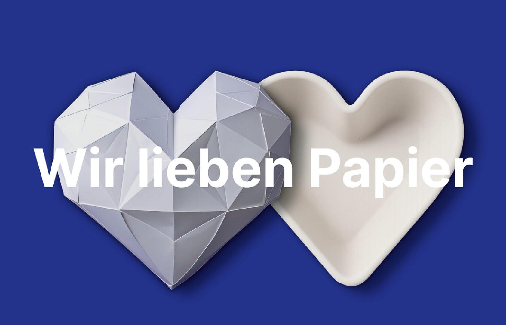 Ein geometrisches Herz aus Papier und eine weiße, herzförmige Schale sind vor einem blauen Hintergrund abgebildet, über das Bild zieht sich der deutsche Text „Wir lieben Papier“.